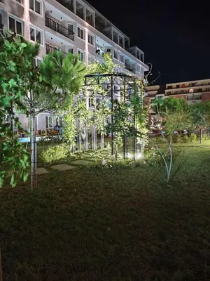 a building at night with trees in front of it at J'Adore Secret Garden, Deluxe Apartment in Sunny Beach