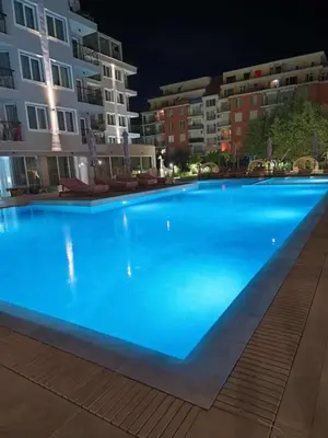 a large blue swimming pool in front of some buildings at J'Adore Secret Garden, Deluxe Apartment in Sunny Beach