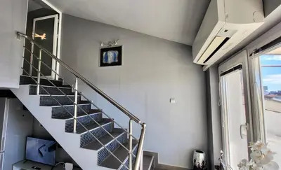 a spiral staircase in a house with a window at Комфорт и стиль - Апартамент с панорамой города in Burgas City