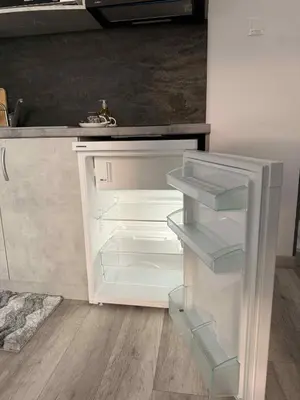 a white refrigerator with its door open in a kitchen at Sun in Varna City