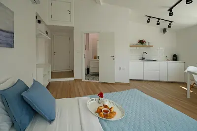 a white room with a plate of food on a bed at The Corner Studio in Varna City