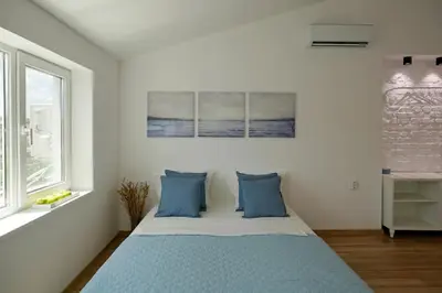 a bedroom with a bed with blue pillows at The Corner Studio in Varna City