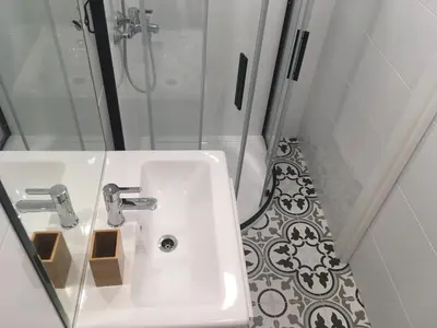 a white sink in a bathroom with a shower at The Corner Studio in Varna City