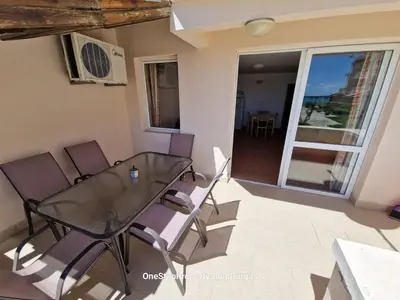 a glass table and chairs on a balcony at Ravda Holiday Village 1-bed seaview apartment in Ravda