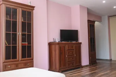 a room with a tv on a wooden dresser with a tvicterictericter at Central Varna Stay with Free Parking by ApartMAX in Varna City