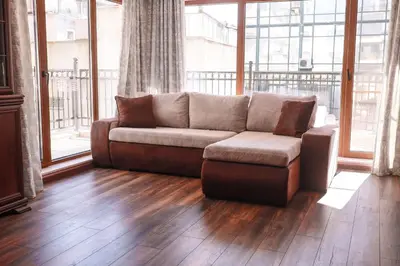 a living room with a couch and a large window at Central Varna Stay with Free Parking by ApartMAX in Varna City