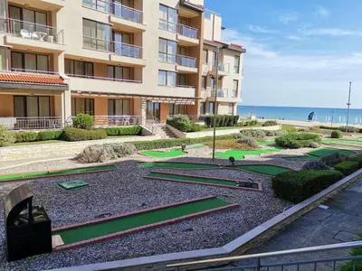 an apartment building with golf courses in front of the ocean at Апартамент E003 в Обзор Бийч Резорт - усещането да живееш на плажа !!! in Obzor