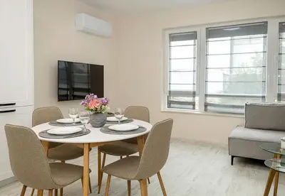 a dining room with a table with chairs and a tv at Casa Novara Apartments - Relax & Enjoy in Central Varna by Flat Mаnаger in Varna City