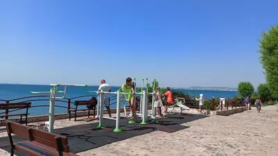 a group of people standing in a park near the water at Fort Noks Grand Resort Wave&Dreams in Sveti Vlas