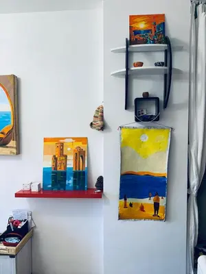 a room with paintings on a wall with shelves at Студия Авангард in Sunny Beach