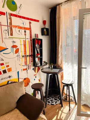 a living room with a table and stools at Студия Авангард in Sunny Beach