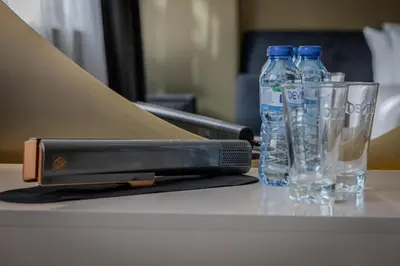 a cell phone and two bottles of water on a table at Aslan Gold Hotel in Varna City