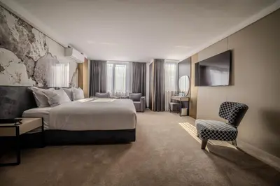 a hotel room with a bed and a chair at Aslan Gold Hotel in Varna City
