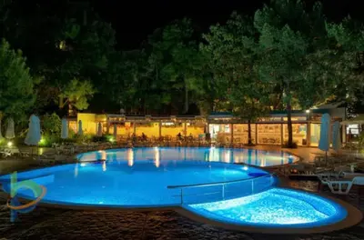 a large blue swimming pool at night at Excelsior Apartment in Sunny Beach