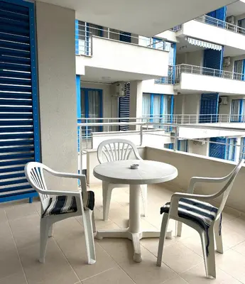 a white table and two chairs and a table and chairs on a balcony at Excelsior Apartment in Sunny Beach