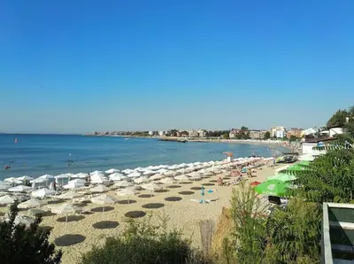 a beach with many umbrellas and people on it at Елегантно Студио В18 в комплекс Одисей, Несебър in Burgas City