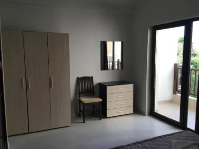 a bedroom with a dresser and a chair and a window at The White Houses 7 in Nesebar