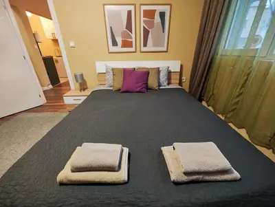 a bedroom with a large bed with two towels on it at PasTelo - 6 min to the Beach & Promenade in Varna City