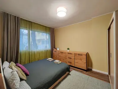 a bedroom with a bed and a dresser and a window at PasTelo - 6 min to the Beach & Promenade in Varna City