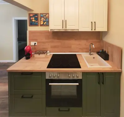 a kitchen with green cabinets and a stove and a sink at PasTelo - 6 min to the Beach & Promenade in Varna City