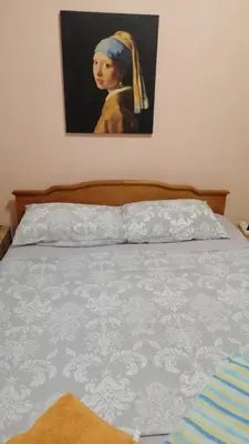 a bedroom with a bed with a painting of a woman at апартамент Климент in Varna City