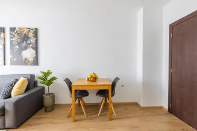 a table and chairs in a living room with a couch at Chic Downtown Flat in Varna City