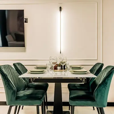a dining room with a table and green chairs at The Loft - Parking - Washer&Dryer - Port view - Balcony in Burgas City