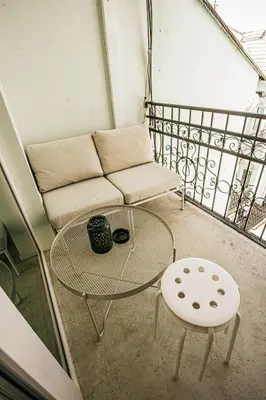 a balcony with a couch and a table and stool at The Loft - Parking - Washer&Dryer - Port view - Balcony in Burgas City