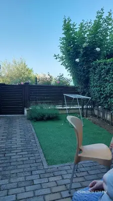 a patio with a chair and a table and grass at Апартамент Феличита in Byala