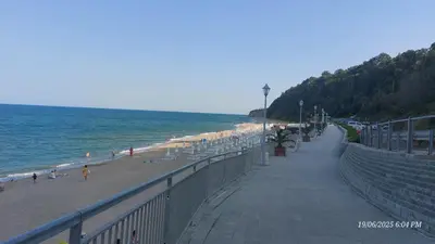 a beach with chairs and people on the beach at Апартамент Феличита in Byala