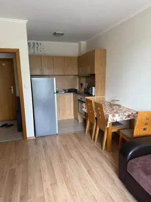 a kitchen and dining room with a table and a refrigerator at Pacific 3 Apartments in Sunny Beach
