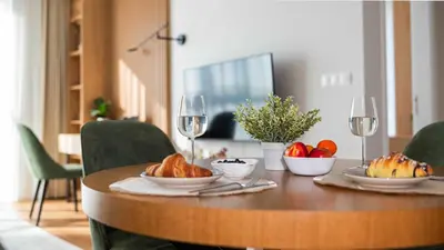 a wooden table with a bowl of bread and wine glasses at Harmony Delux Apartment -Free parking in Burgas City