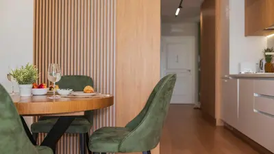 a dining room with a table and green chairs at Harmony Delux Apartment -Free parking in Burgas City