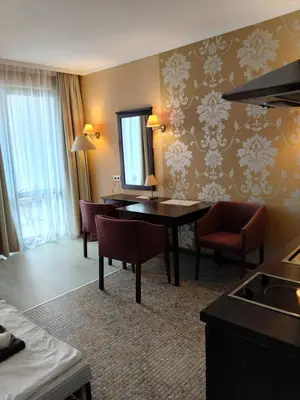 a living room with a table and chairs and a mirror at Studio Royal Beach Barcello in Sunny Beach