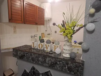 a kitchen counter with a vase with joy spelled out on it at Бюджетна стая за двама in Pomorie