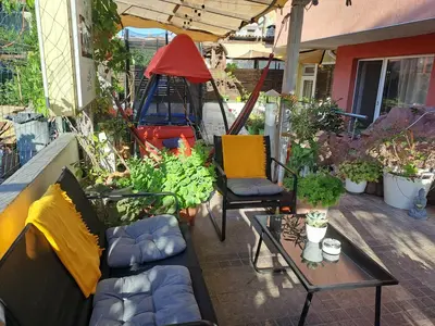 a patio with a couch and chairs on a balcony at Бюджетна стая за двама in Pomorie