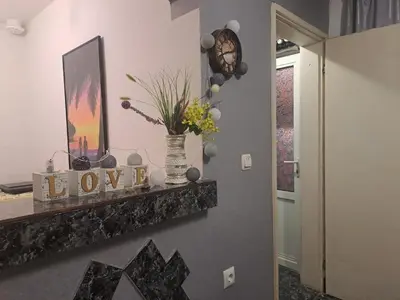 a room with a vase with flowers on a shelf at Бюджетна стая за двама in Pomorie