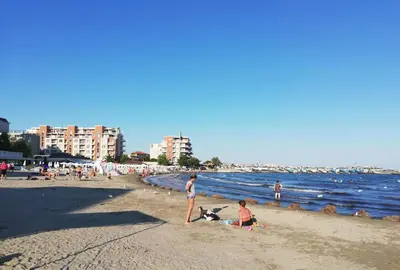 a group of people on a beach with the ocean at Sunny Day Apartment in Pomorie