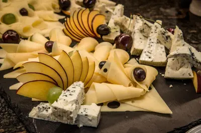 a plate of cheese and fruit on a table at Premier Fort Sands Resort - Full Board in Sunny Beach