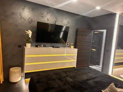 a bedroom with a dresser with a television on it at Golden Pearl of Luxury - Burgas in Burgas City
