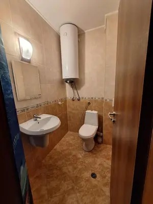 a bathroom with a toilet and a sink at Бобс апартаменти 2 in Kiten