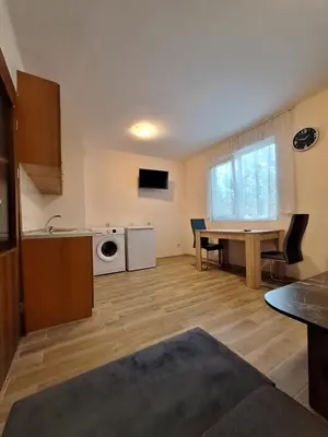 a kitchen and living room with a table and a microwave at Бобс апартаменти 2 in Kiten