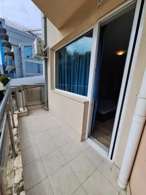 a balcony with a large window on a building at Бобс апартаменти 2 in Kiten
