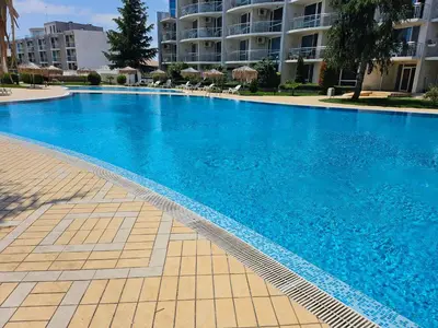 a large blue swimming pool in front of a building at Студио за двама в Сарафово in Burgas City