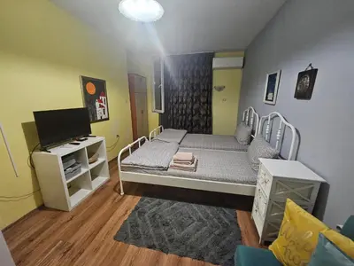 a small room with a bed and a tv at Стая за двама в град Бургас in Burgas City