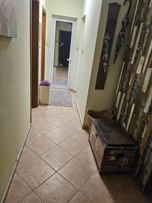 a hallway with a tiled floor with a trunk on it at Стая за двама в град Бургас in Burgas City