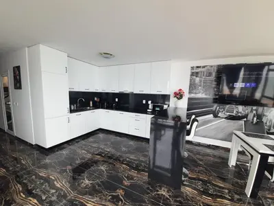 a large kitchen with white cabinets and a table at Luxe 1 Monte Carlo Suite in Obzor
