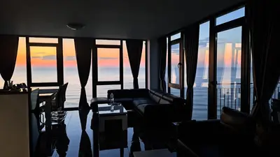 a living room with a couch and some windows at Luxe 1 Monte Carlo Suite in Obzor