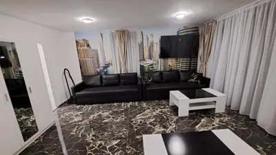 a living room with a black couch and a table at Luxe 1 Dubai Penthouse in Obzor