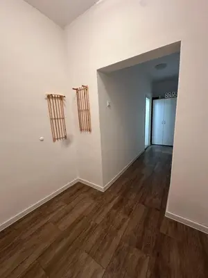 an empty room with white walls and wooden floors at Ssenyange Sea Garden Apartment in Varna City